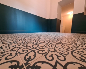 Réalisation d’un carrelage, lissage et peinture des murs dans l’entrée de cette maison de village à Cossonay
